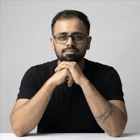 Akash Solanki at a desk, waving at the camera